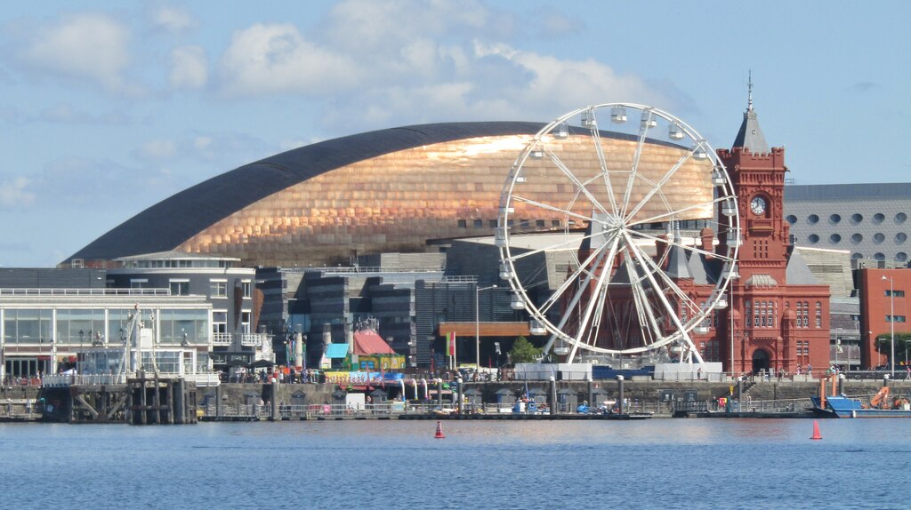 Trivallis Housing Landlord Wales A ferris wheel and Wales Millenium Centre in Cardiff Bay are situated by the waterfront, with a clear blue sky in the background.