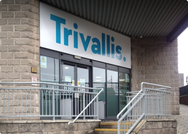 Trivallis Housing Landlord Wales The entrance to a Trivallis housing building features glass doors and a metal railing leading up a series of steps, with the sign 