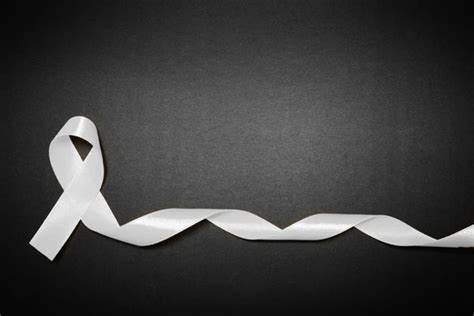 Trivallis Housing Landlord Wales A twisted white ribbon against a dark grey background, with one end looped into a simple knot shape, symbolizing a cause or awareness campaign.