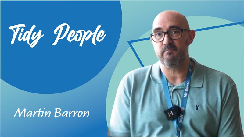 Trivallis Housing Landlord Wales A man with glasses and a beard wears a light green polo shirt and a lanyard, sitting in front of a blue and teal background with the text "Tidy People" and "Martin Barron.